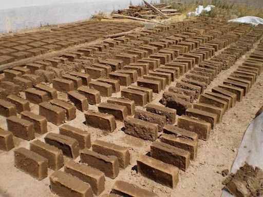 Fabricación de ladrillos de adobe unidos por una masa de mortero y caña.